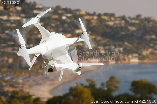 Image of Unmanned Aircraft System (UAV) Quadcopter Drone In The Air Over 