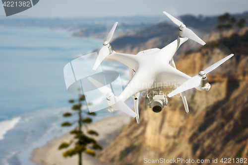 Image of Unmanned Aircraft System (UAV) Quadcopter Drone In The Air Over 