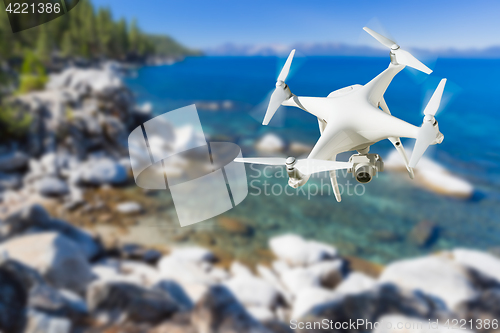 Image of Unmanned Aircraft System (UAV) Quadcopter Drone In The Air Over 