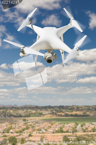 Image of Unmanned Aircraft System (UAV) Quadcopter Drone In The Air Over 