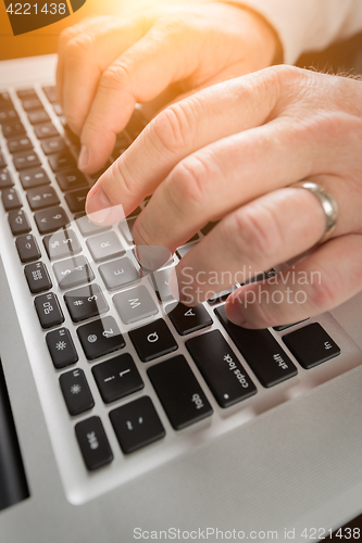 Image of Male Hands Typing on Laptop Computer Keyboard.