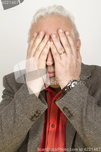 Image of Senior hands his face