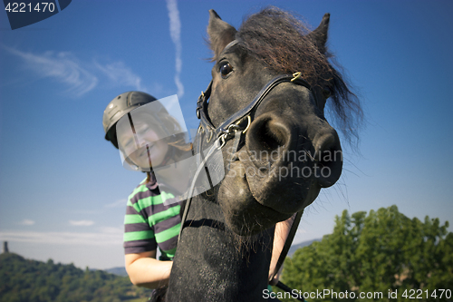 Image of Beautiful young woman rides her black Horse 
