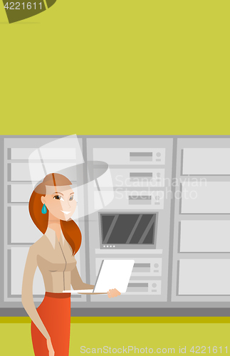 Image of Engineer working on laptop in network server room.