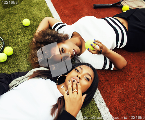 Image of young pretty girlfriends hanging on tennis court, fashion stylis