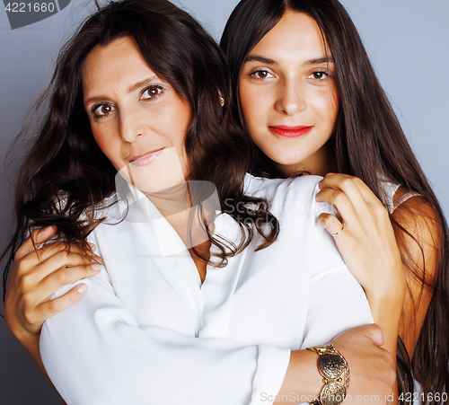 Image of cute pretty teen daughter with mature mother hugging, fashion st