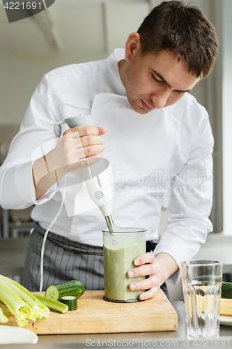 Image of Young male chef making smoothie