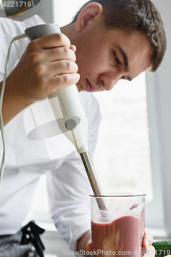 Image of Young male preparing smoothie