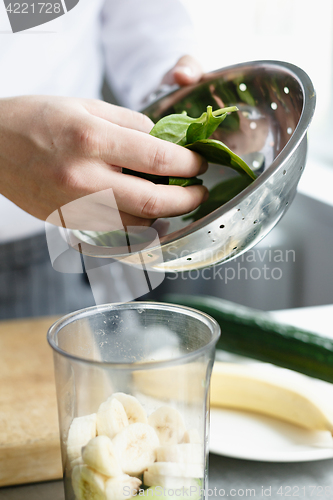 Image of Crop hands making fresh smoothie