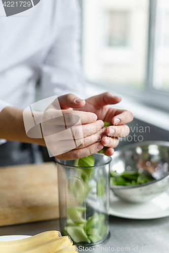 Image of Crop hands pouring cut celery in container