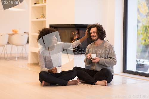 Image of multiethnic couple  in front of fireplace