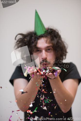 Image of man blowing confetti in the air