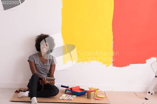 Image of back female painter sitting on floor