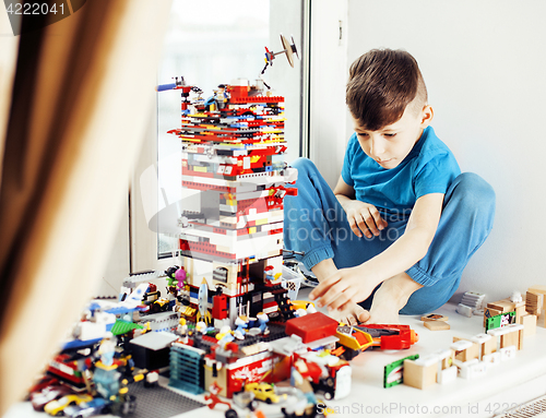 Image of little cute preschooler boy playing lego toys at home happy smiling, lifestyle children concept 