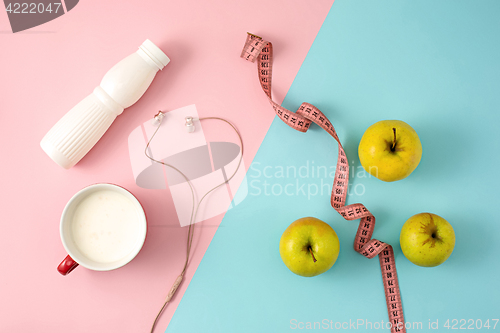 Image of The green apple and bottle of yogurt with measure tape