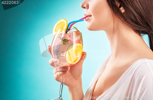 Image of The pretty woman drinking cocktail. Emotion. Hairstyle.