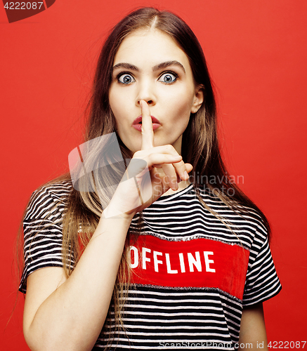 Image of young pretty emitonal posing teenage girl on bright red background, happy smiling lifestyle people concept 