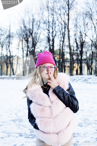 Image of young pretty teenage hipster girl outdoor in winter snow park having fun drinking coffee, warming up happy smiling, lifestyle people concept