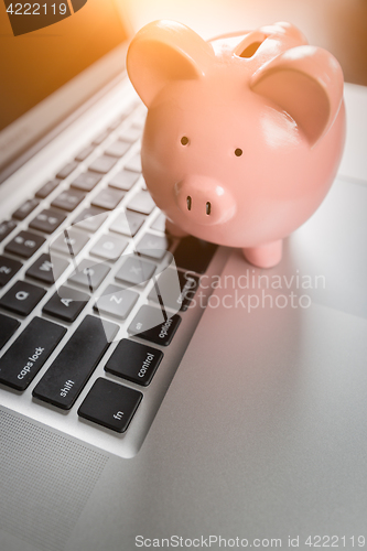 Image of Piggy Bank Resting on Laptop Computer Keyboard.