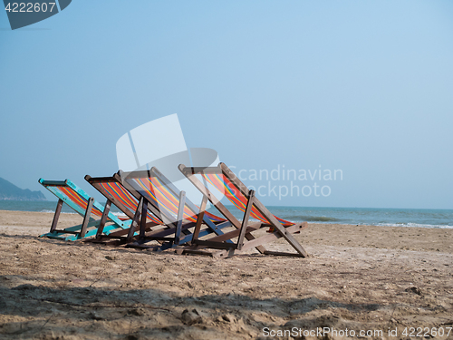 Image of Four deck chairs on beach