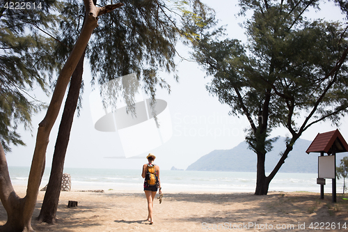 Image of Young girl walks along beach