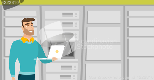 Image of Engineer working on laptop in network server room.