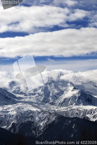 Image of View on snow mountains and sunlight cloudy sky at winter day