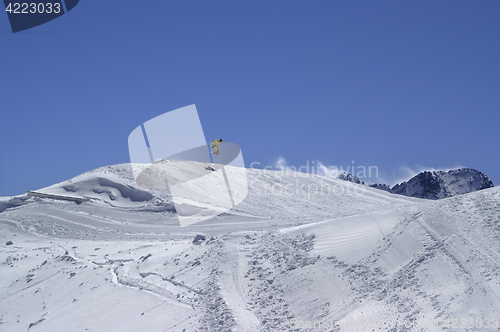 Image of Snowboarder jumping in terrain park at ski resort on sun winter 