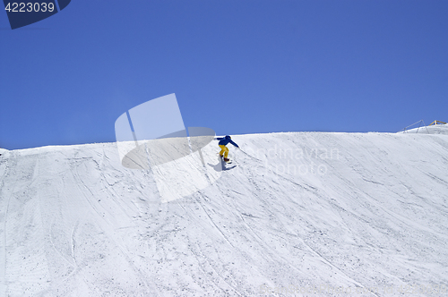 Image of Snowboarder downhill in terrain park on ski resort at sun winter