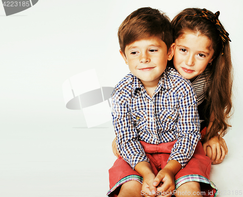 Image of little cute boy and girl hugging playing on white background, ha