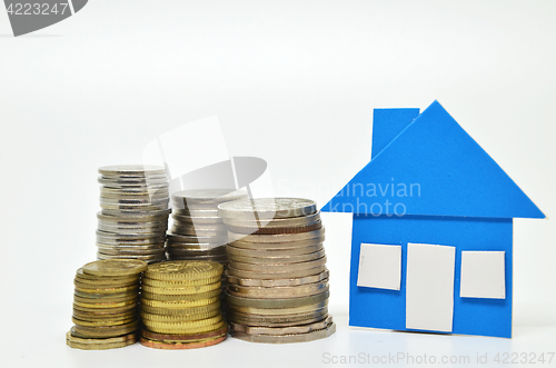 Image of House model and stacks of coins