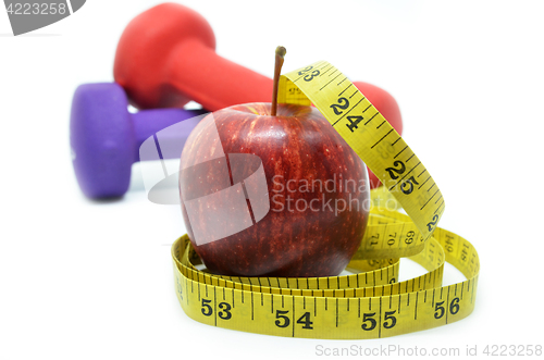 Image of Dumbbell with measuring tape and red apple