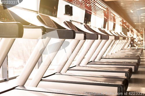 Image of Woman running in a gym on a treadmill concept for exercising, fitness and healthy lifestyle