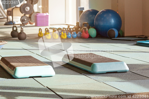 Image of interior of rehabilitation gym, with equiment: balls, mats, steps