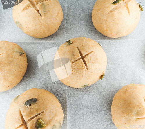 Image of Pumkin seed buns proofing on baking paper at close-up