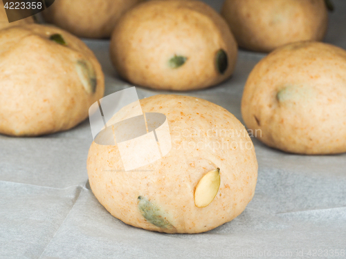 Image of Pumkin seed buns proofing on baking paper at close-up