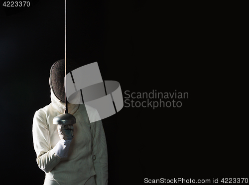 Image of The portrait of woman wearing white fencing costume on black