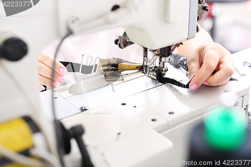 Image of Production of apparel. Occupation needlewoman. Sewing underwear.