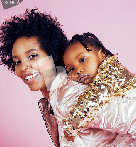 Image of young pretty african-american mother with little cute daughter hugging, happy smiling on pink background, lifestyle modern people concept 