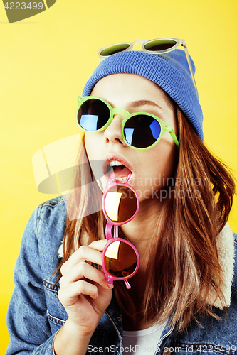Image of young pretty long hair teenage hipster girl posing emotional happy smiling on yellow background, lifestyle people concept 