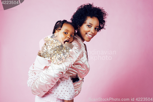 Image of young pretty african-american mother with little cute daughter hugging, happy smiling on pink background, lifestyle modern people concept 