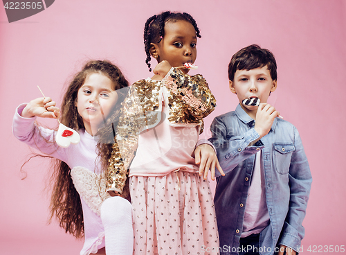 Image of lifestyle people concept: diverse nation children playing together, caucasian boy with african little girl holding candy happy smiling 