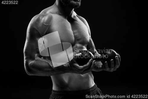 Image of The torso of attractive male body builder on black background.