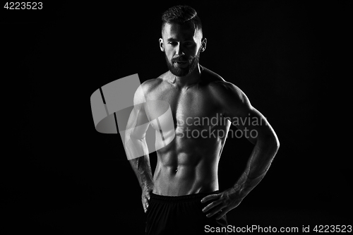 Image of The torso of attractive male body builder on black background.