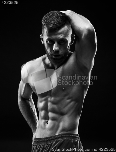 Image of The torso of attractive male body builder on black background.