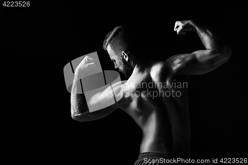 Image of The back view torso of attractive male body builder on black background.