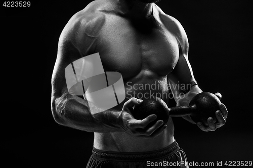 Image of The torso of attractive male body builder on black background.