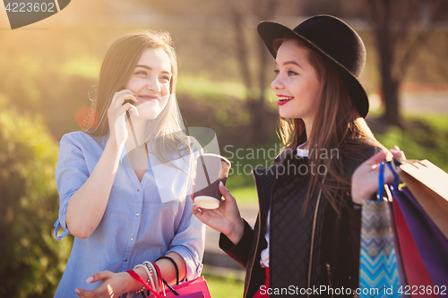 Image of Two girls walking with shopping on city streets