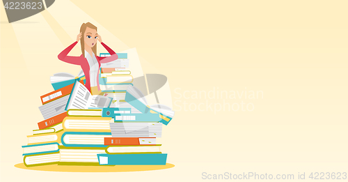 Image of Student sitting in huge pile of books.