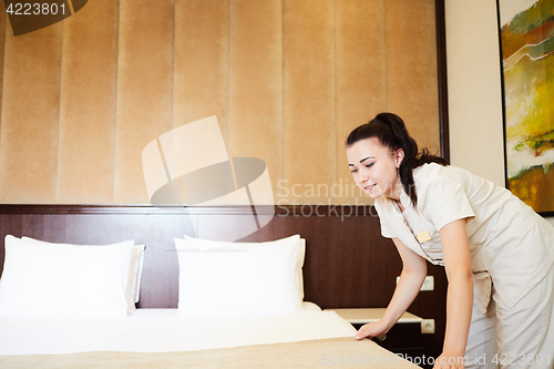 Image of Hotel service. Made making bed in room.